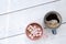 Mug of hot chocolate with small marshmallows next to a mug of black coffee isolated on white painted wood from above. Space for