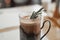 A mug of hot cocoa with a rosemary branch in a vintage metal cup holder. Retro style food photo concept. Blurred