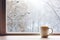 Mug of hot coffee by the winter window, a peaceful January vibe