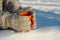 Mug with hot drink in hands dressed in knitted wool mittens in winter on a Sunny frosty day, winter picnic