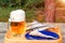 Mug of light beer and dried fish on a wooden table in a summer day outdoors - photo, image