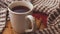 A Mug of Tea on a Wooden Plaque Surrounded by a Crocheted Scarf