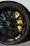 Mugello Circuit, Italy - 23 September 2021: detail of an alloy wheel rim with yellow brake caliper of a Porsche 911 in the paddock