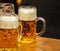 Mugs of beer on a wooden table, closeup view. Oktoberfest, Munich, Bavaria