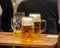 Mugs of beer on a wooden table, closeup view. Oktoberfest, Munich, Bavaria