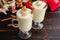 Mugs of Eggnog Topped with Whipped Cream and Cinnamon with a Christmas Setting