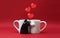 Mugs in the form of cats in love on a red background with hearts. Concept valentines day postcard, banner.