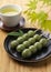 Mugwort-flavored rice dumpling and green tea on a wooden table