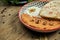 Muhammara is a classic eastren dish. baked pepper and walnut puree with Bazlama and yogurt in a ceramic plate on a wooden