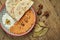 Muhammara is a classic eastren dish. baked pepper and walnut puree with Bazlama and yogurt in a ceramic plate on a wooden