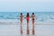 MUI NE, VIETNAM - MARCH 11, 2017: Three young lesbian girlfriends girls run along the beach to the ocean on summer