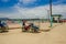 Muisne, Ecuador - March 16, 2016: Local tuktuk driver sitting in his vehicle next to ocean waiting for passengers on a