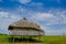 Muisne, Ecuador - March 16, 2016: Old traditional bungalow sitting on woden poles above grassy surface, beautiful blue