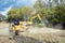 Mulcher and Backhoe Clearing Field with Stormy Sky