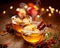 Mulled cider with slice apples, cinnamon, cloves, anise stars and citrus fruits in glass cups on a wooden rustic table, close-up.