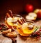 Mulled cider with slice apples, cinnamon, cloves, anise stars and citrus fruits in glass cups on a wooden rustic table, close-up.