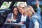 Mulling over a map. Portrait of a group of friends leaning against their van, reading a map.