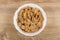 Multi cereal flakes in bowl on wooden table. Top view