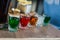 Multi-color cool alcohol party drinks with on wooden table in bar. Bright colorful glasses with alcoholic shots. Mixed