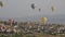 Multi-colored balloons fly over rocks