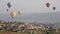 Multi-colored balloons fly over rocks.