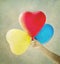 Multi colored balloons toned with a retro vintage background