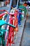 Multi-colored bicycles stand side by side on the street