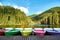 Multi-colored boats at the pier on Lake Lacu Rosu, Romania. Autumn landscape of mountain lake