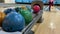 Multi-colored bowling balls close-up. Woman throws a bowling ball.