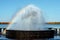 Multi-colored bright rainbow in the fountain is reflected in the water on a sunny bright day in the city