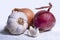 Multi colored bulb onions and a white head of garlic close up on a white background