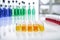 multi-colored chemistry vials arranged on white lab table