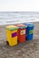 multi-colored containers for sorting garbage are on the beach ag