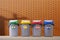 Multi Colored garbage bins on pavement with blurred artificial brick wall background