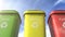 Multi colored garbage bins with waste type separation labels and recycle logos