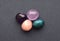 Multi-colored gemstones, cut tumbling stones. Amethyst, rose quartz, apatite  on a gray background
