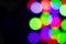 Multi-colored glares side on a black background with room for copyspace text. Festive New Year`s background. Bokeh