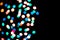 Multi-colored glares side on a black background with room for copyspace text. Festive New Year`s background bokeh