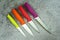 Multi-colored kitchen knives: red, burgundy, orange, yellow