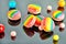 Multi colored macaron and chewing gum balls on a gray background with reflection