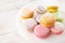 Multi-colored macarons on wood background with soft lights and shadows. Gentle macaroons on table on light background