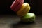 Multi-colored macaroons on a wooden tray. Pink, yellow and green macaroon.