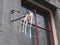 Multi colored paper garlands hanging on a cast iron bow on a stone wall