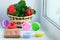 Multi-colored plasticine for modeling in a round package and tools on a wooden board are prepared for work. Red flower in the