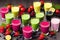 multi-colored smoothies in different glasses stand on a dark wooden table, berries, fruits and greens are cut nearby