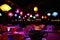 Multi Colored Tea Cups On Table Against Illuminated Lamps Hanging From Ceiling At Home