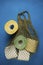 Multi-colored toilet paper in a string bag on a blue background. Consumer buying panic about coronavirus covid-19. Concept- Buying