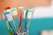 Multi-colored toothbrushes in a glass beaker. Copy space