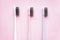 Multi-colored toothbrushes on a pink background close-up, flat lay composition