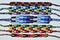 Multi-colored woven friendship bracelets handmade of embroidery bright thread with knots on light gray background
